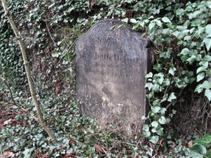J T Bailey is buried to the left of this grave which is against the west wall.