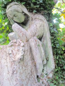Kneeling figure with wreath. Detail from the monument.